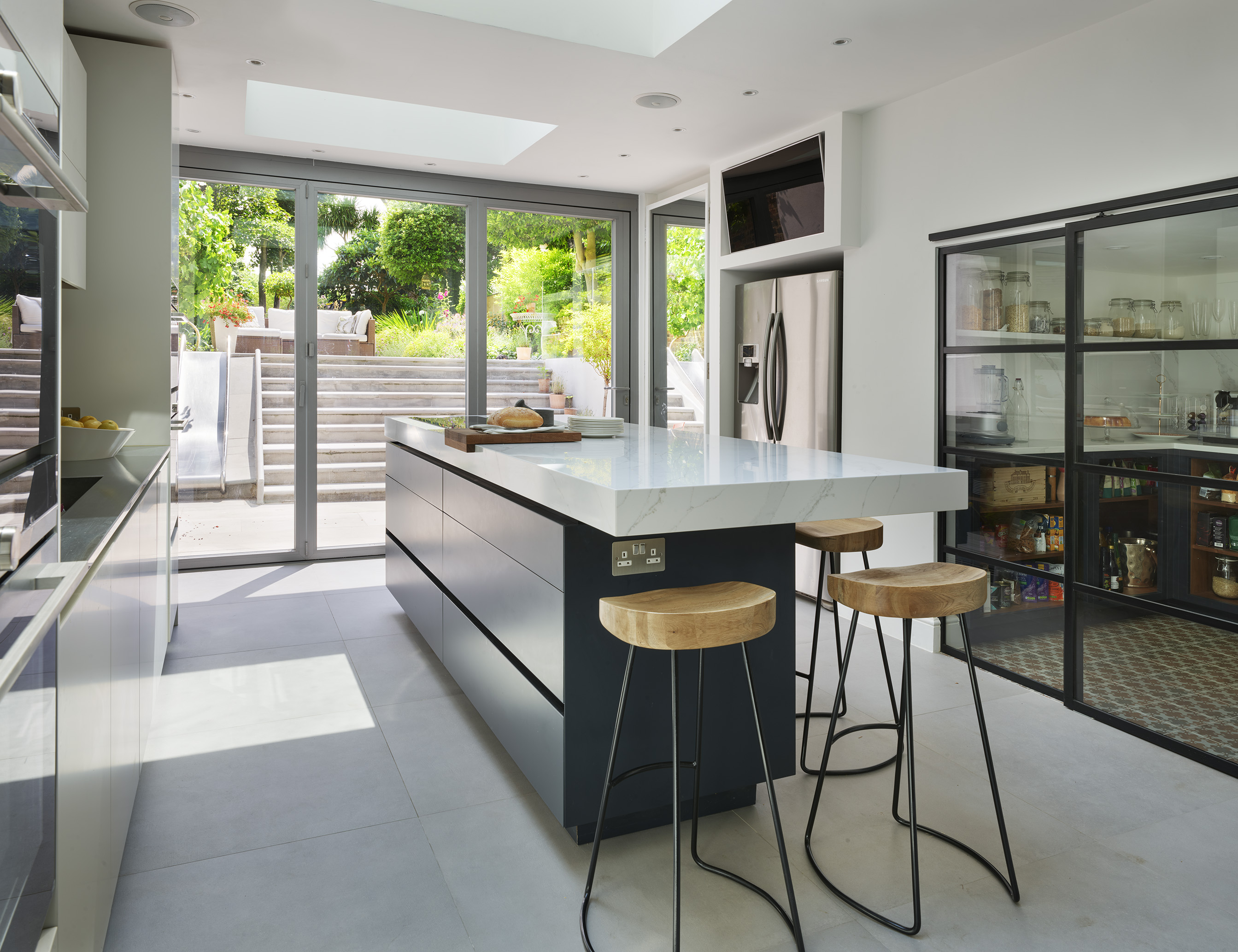 Luxury kitchen design by Roundhouse with bespoke kitchen island and white marble work surface
