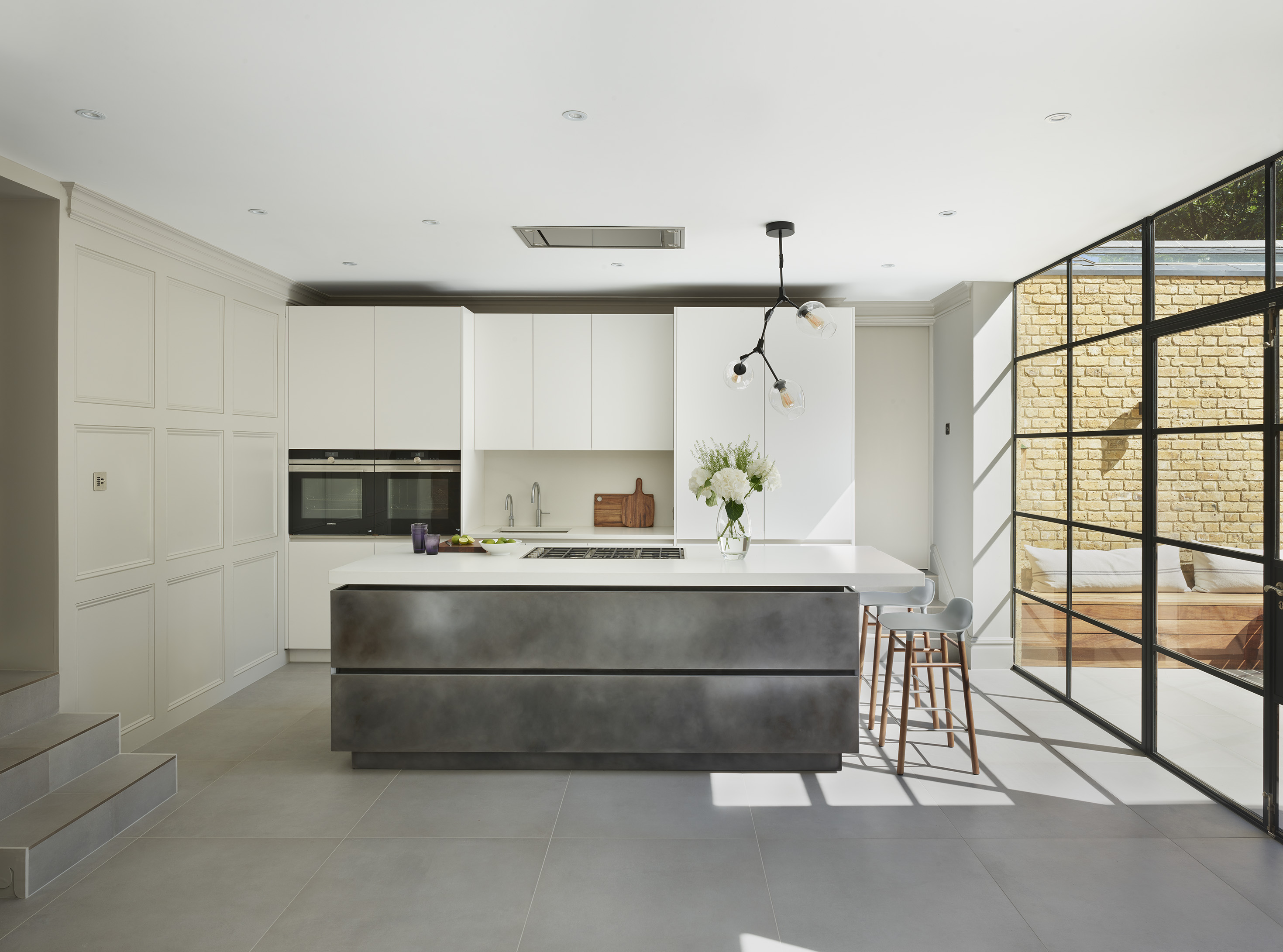 Kitchen lighting pendant with kitchen designs by Roundhouse and silver patinated kitchen island with white work surface