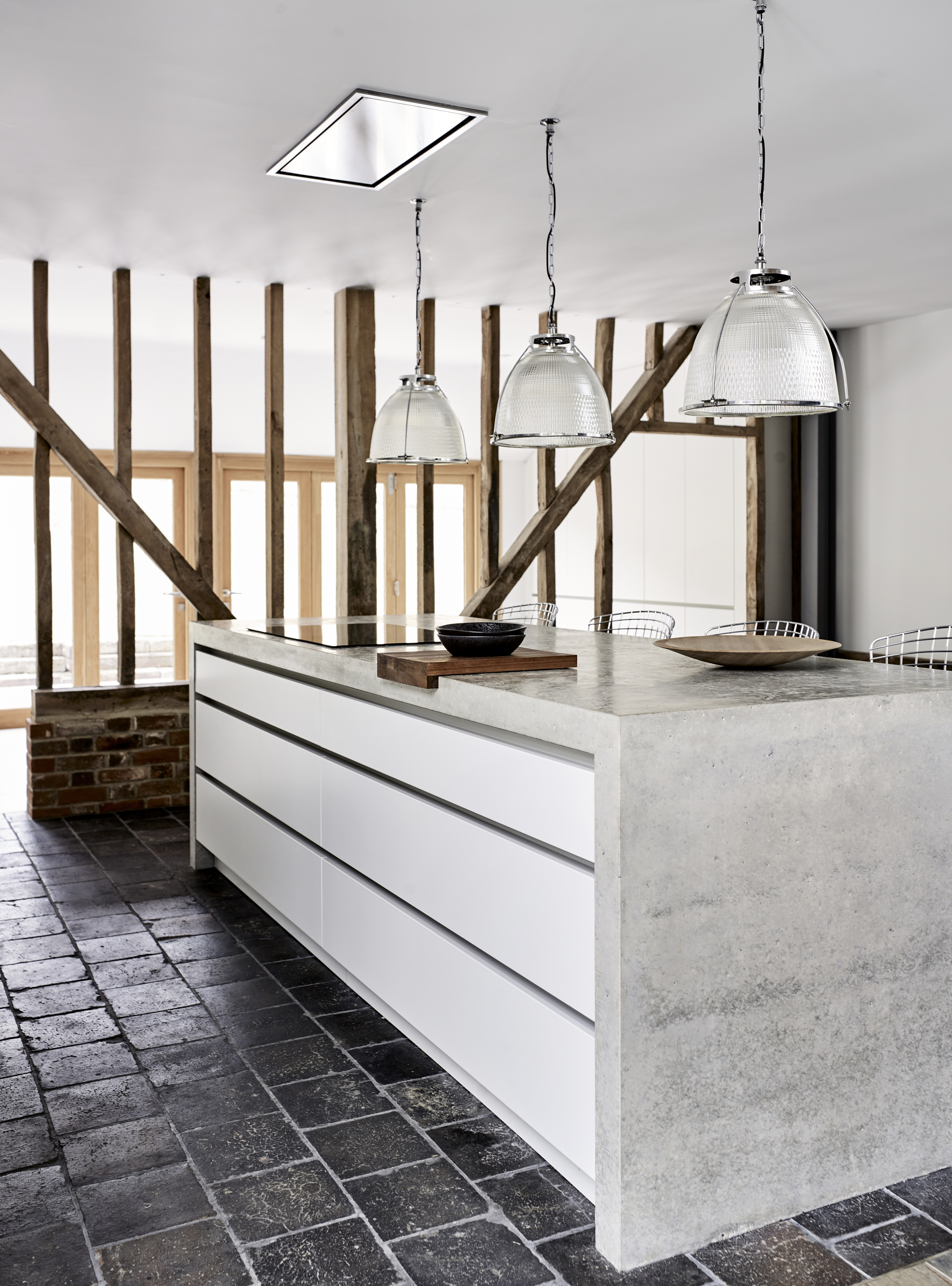 Modern kitchen lighting with bespoke kitchen island and concrete work surface