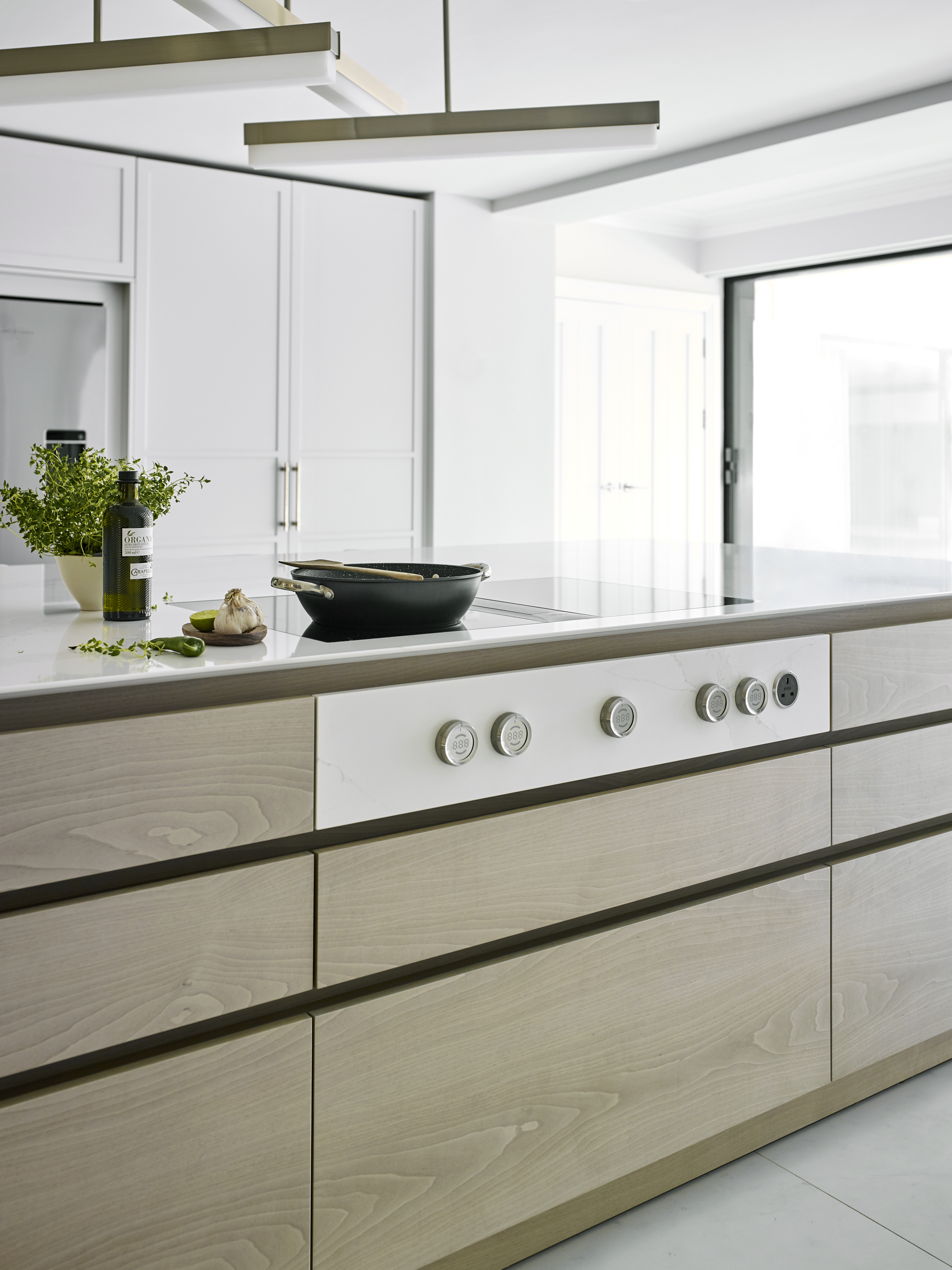 Kitchen lighting over a bespoke kitchen island with white marble work surface