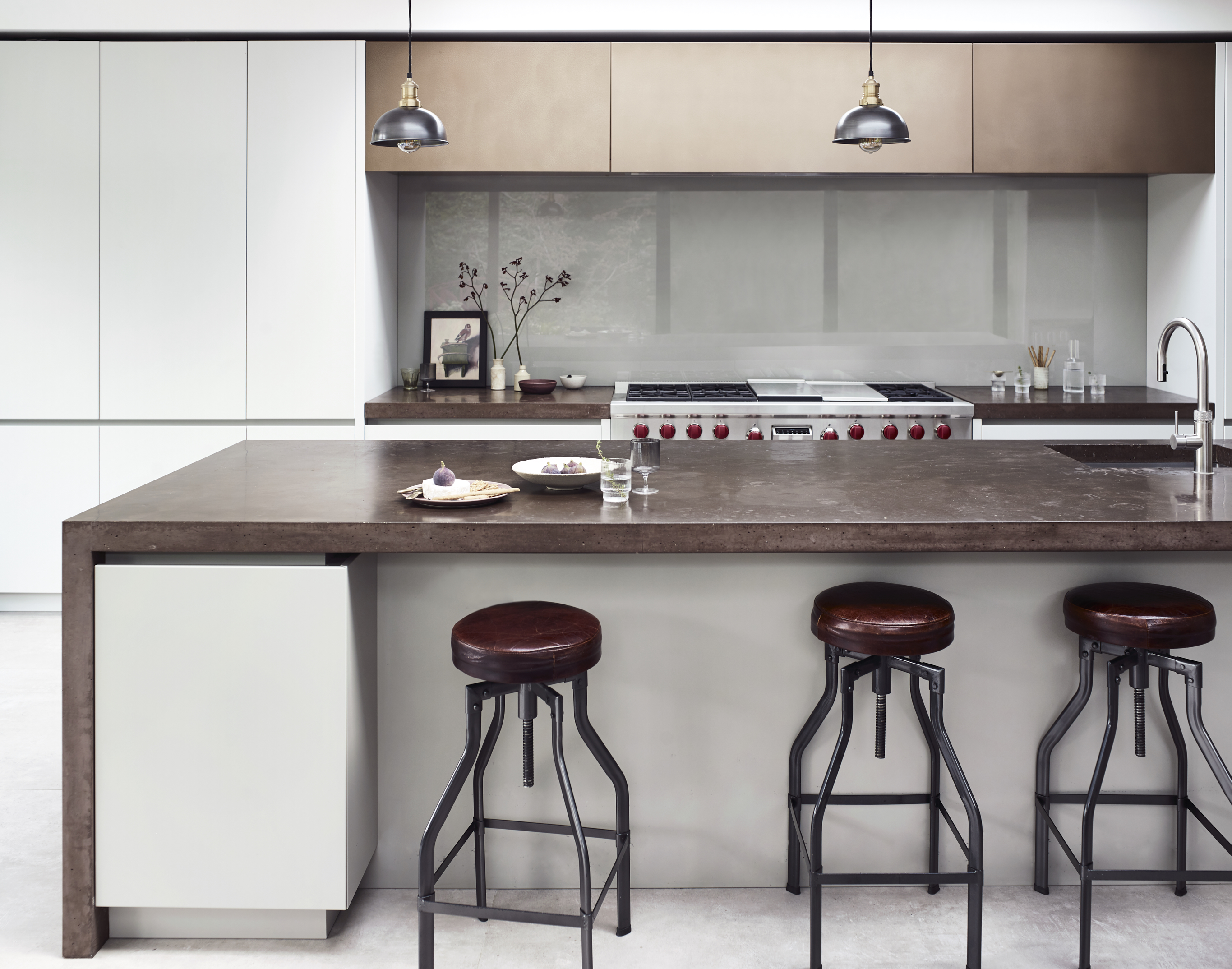 Kitchen islands by Roundhouse with brass work surface and bespoke kitchen cabinets