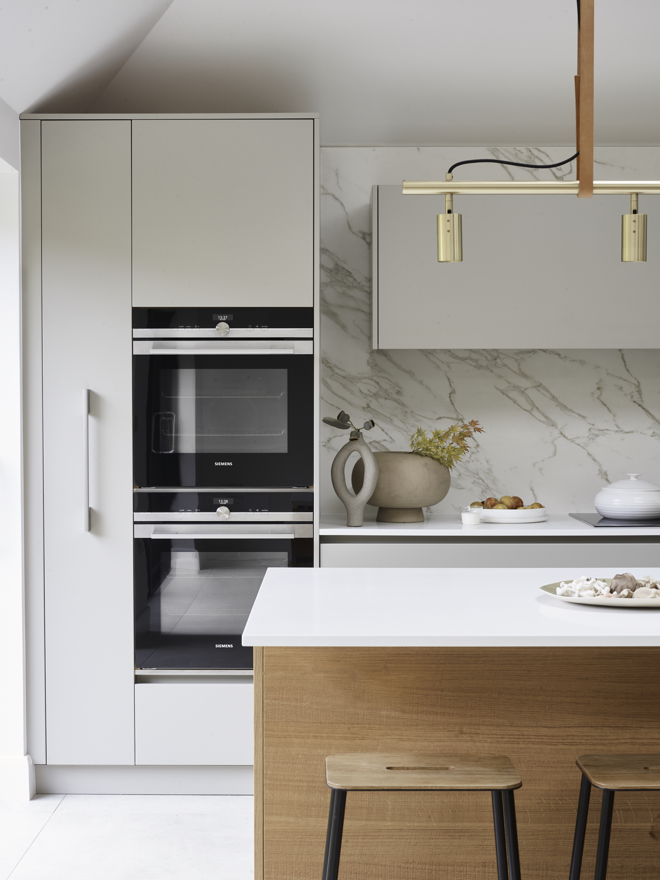 Custom kitchen by roundhouse with kitchen island in oak and white work surface