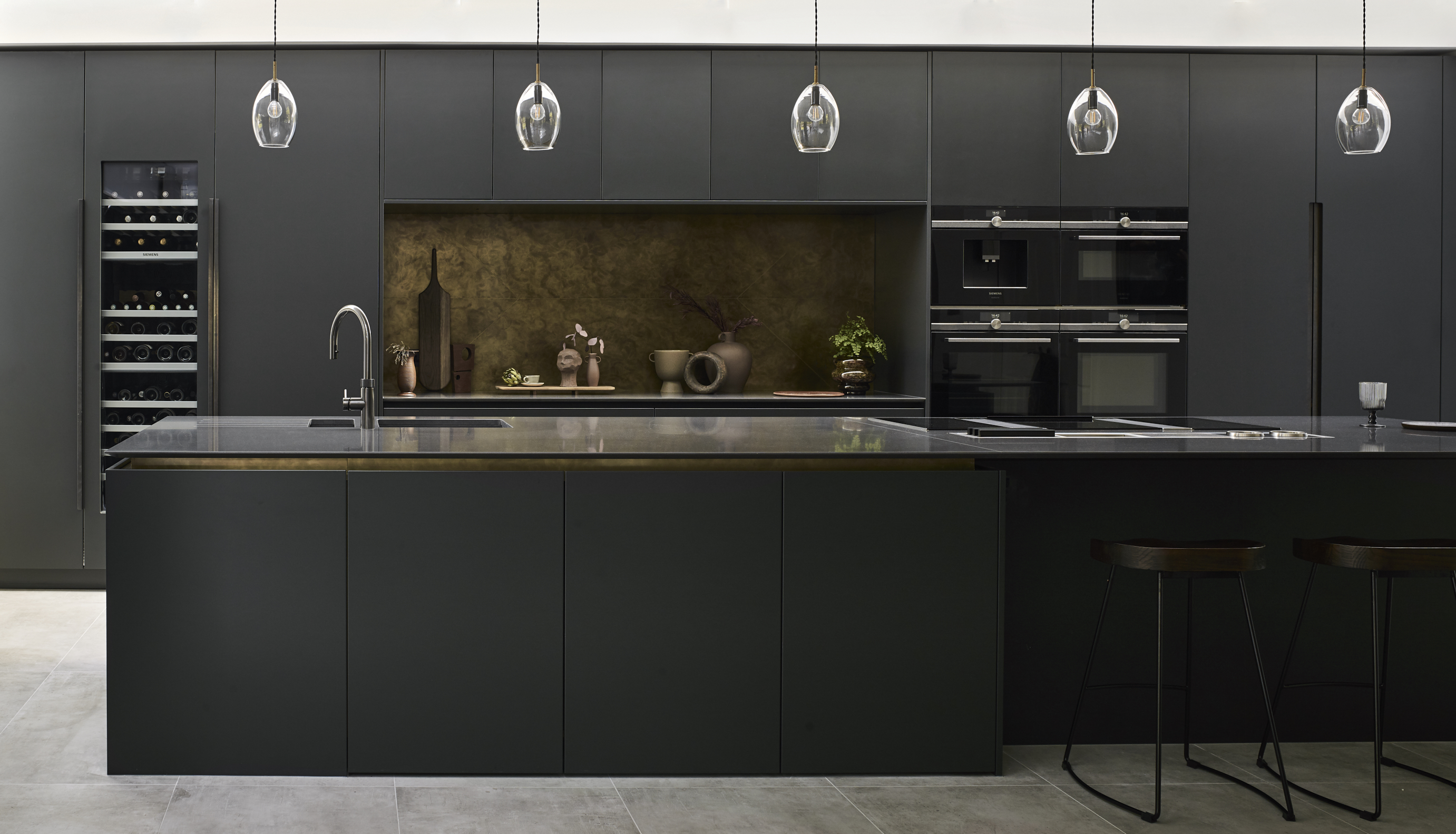Luxury kitchen design with bespoke kitchen island with black and brass work surfaces