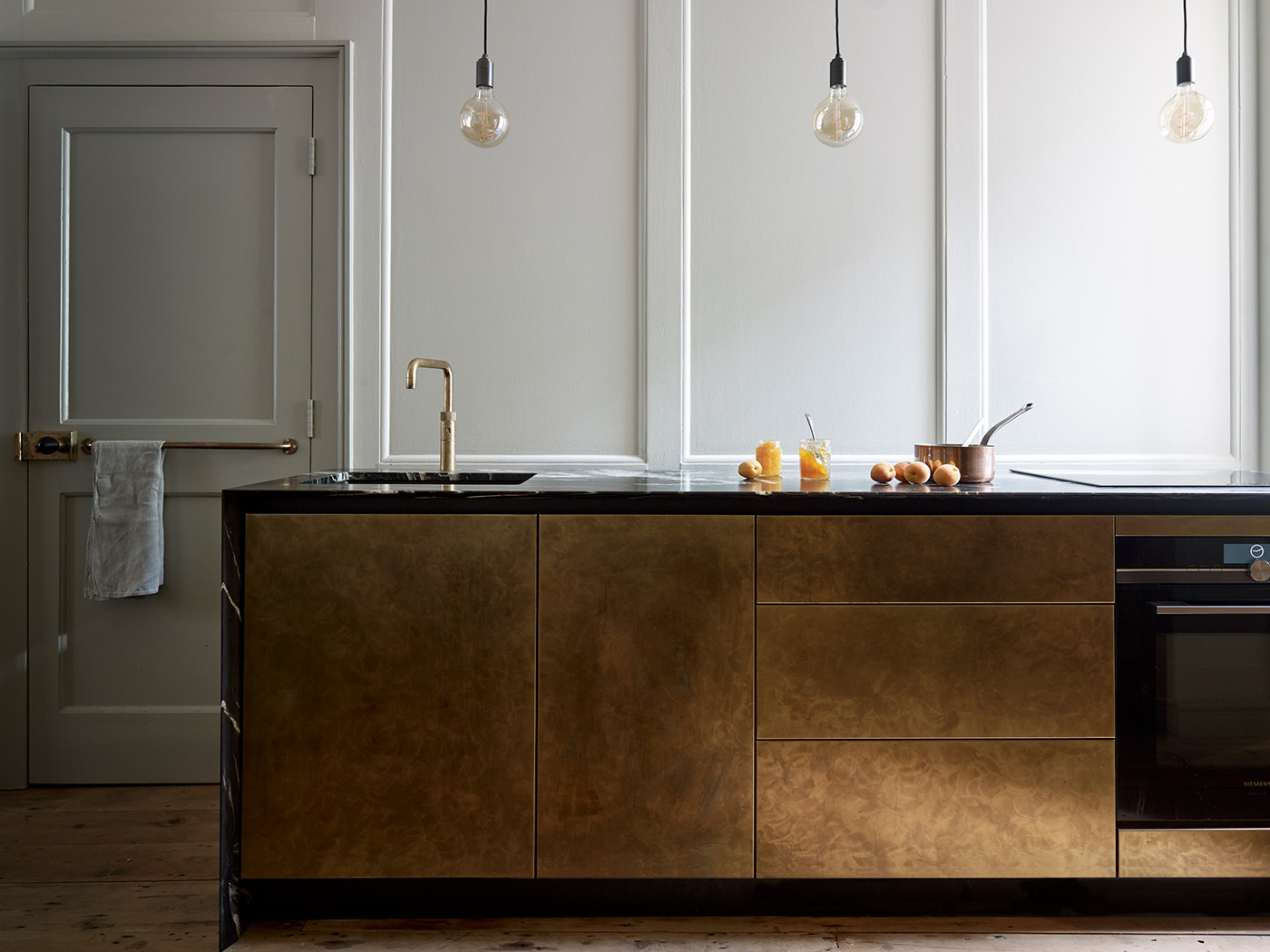 Contemporary kitchen design brass island with marble work surface