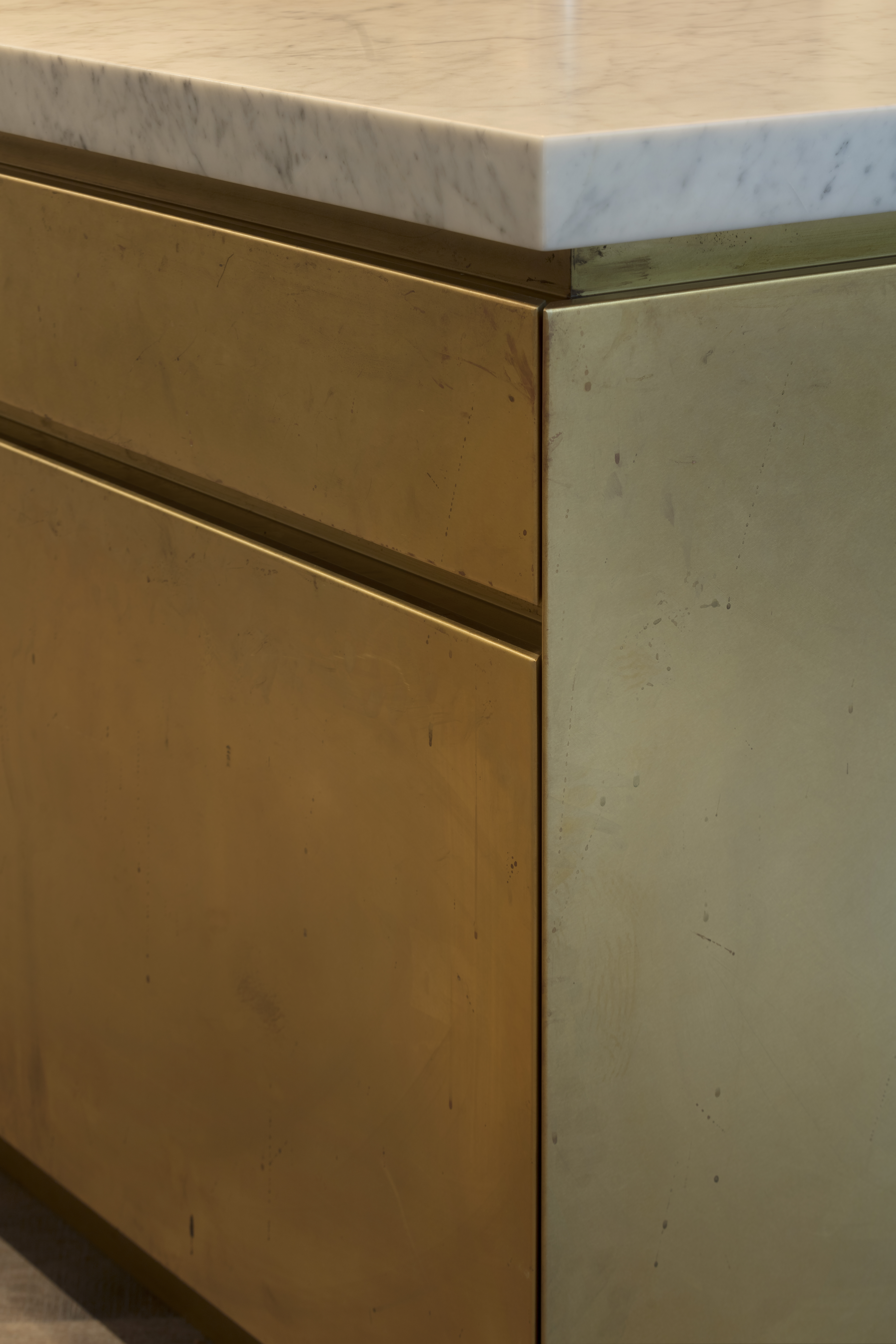 kitchen island in brass with marble work surfaces