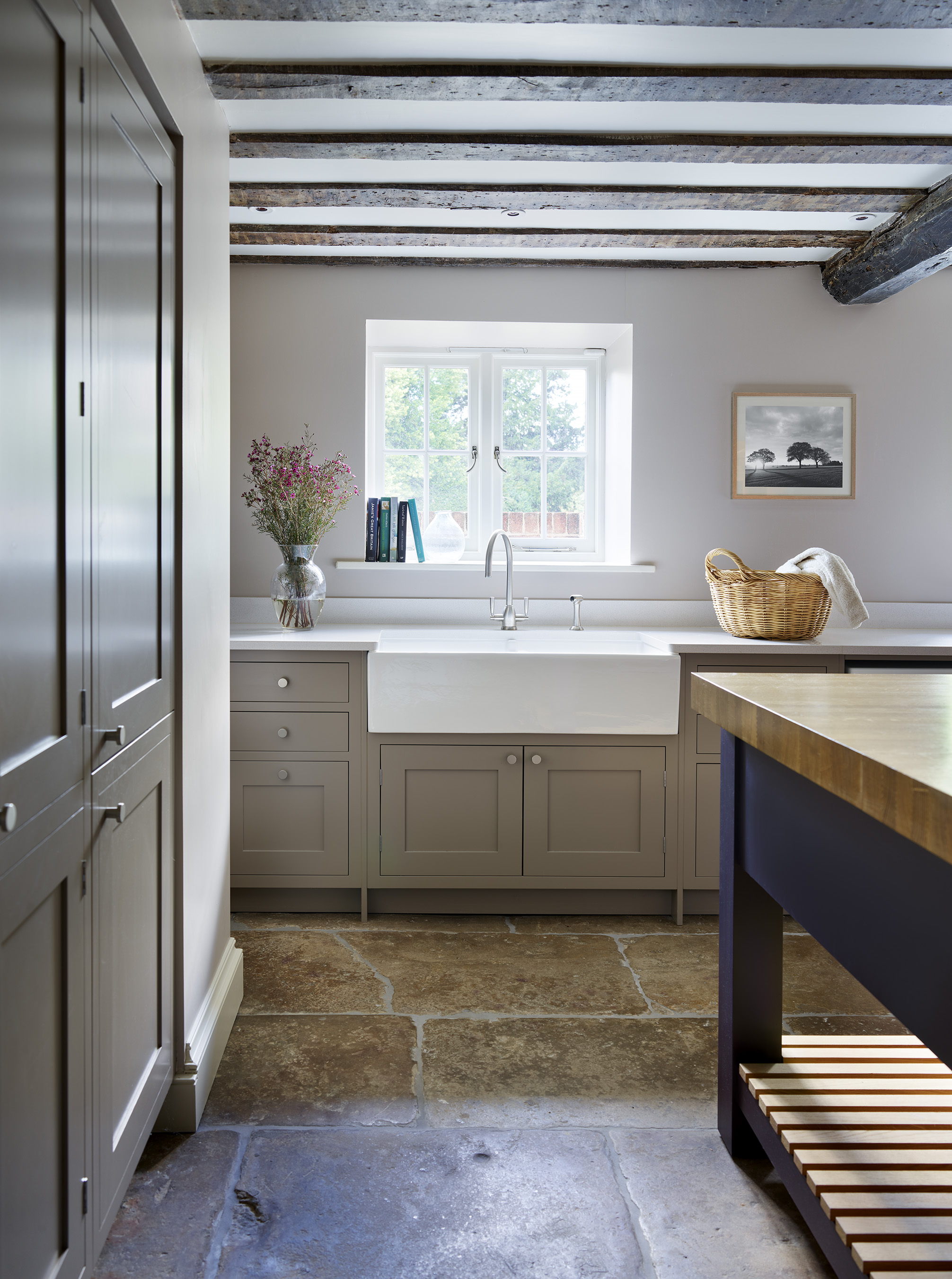 Luxury bespoke utility room with blue and oak island with sink