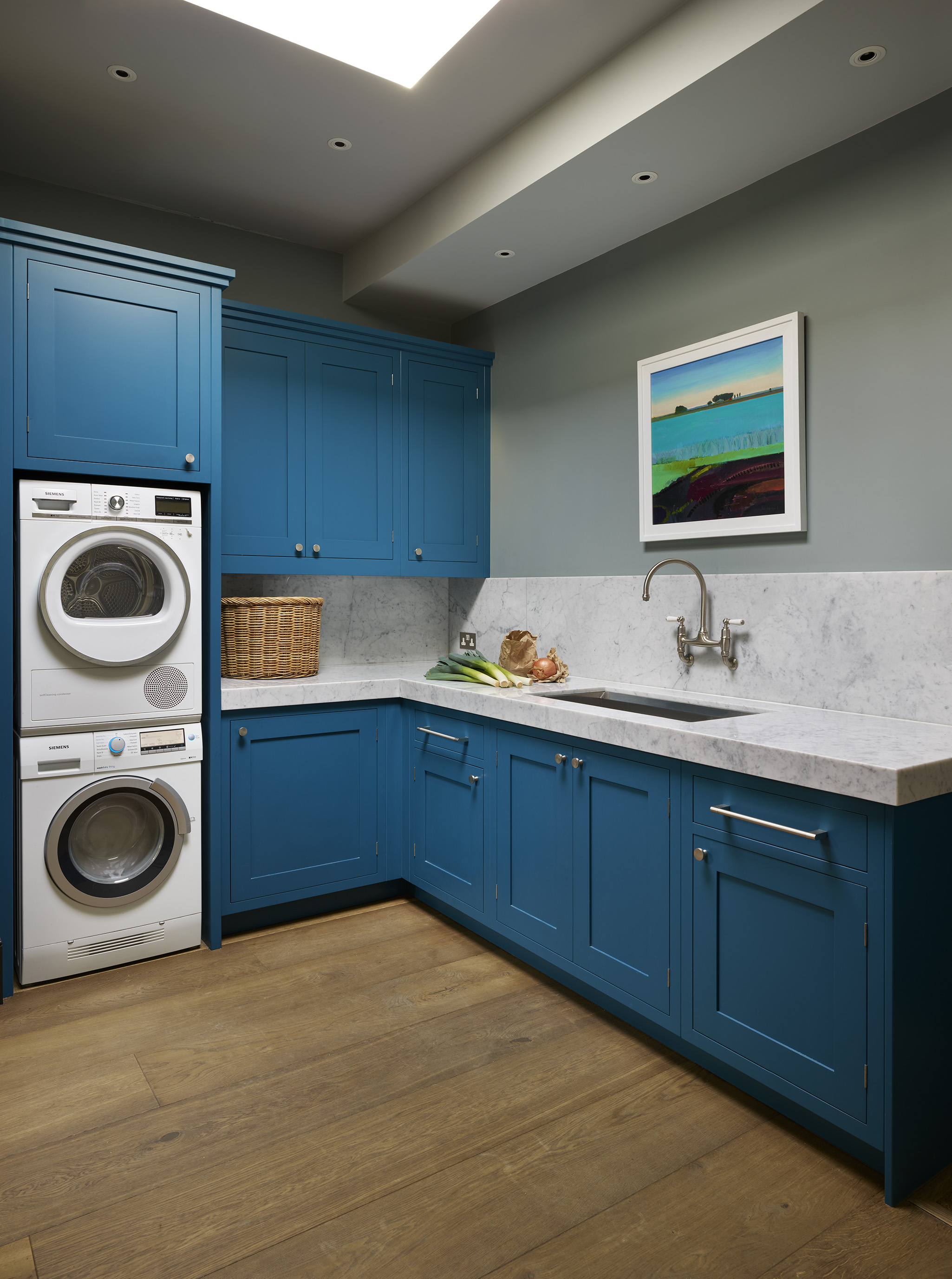 Designer utility room in bright blue with marble worktop