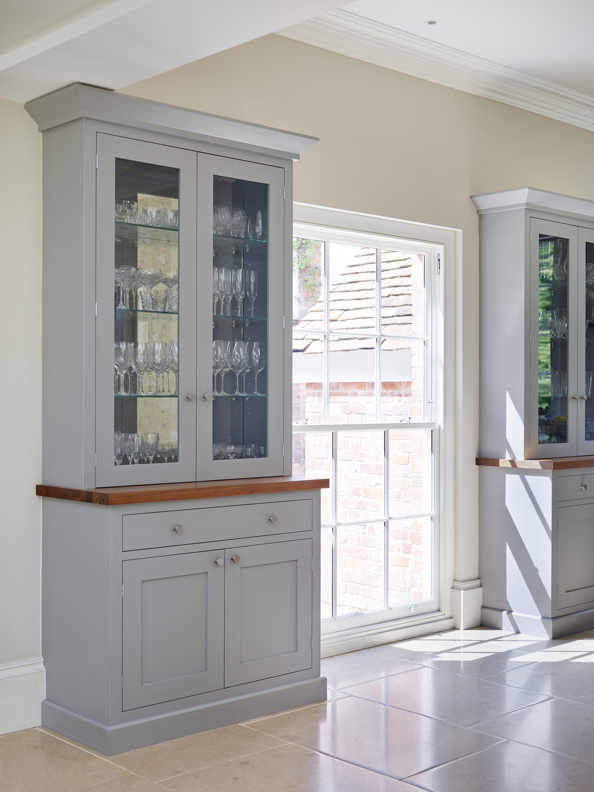 Luxury bespoke tall kitchen storage with glass shelving and doors