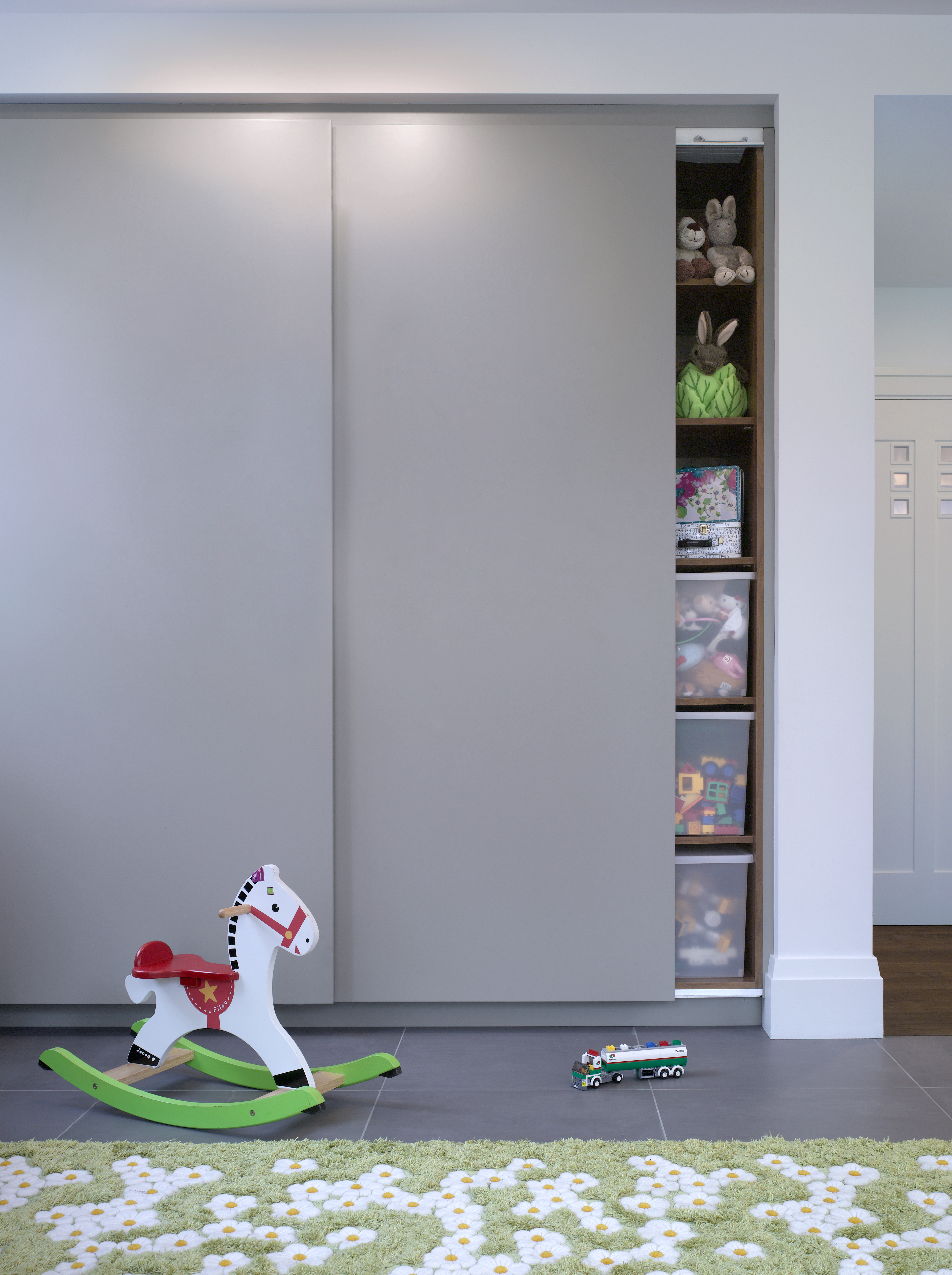 Bespoke contemporary storage cupboard for children's play room with sliding doors