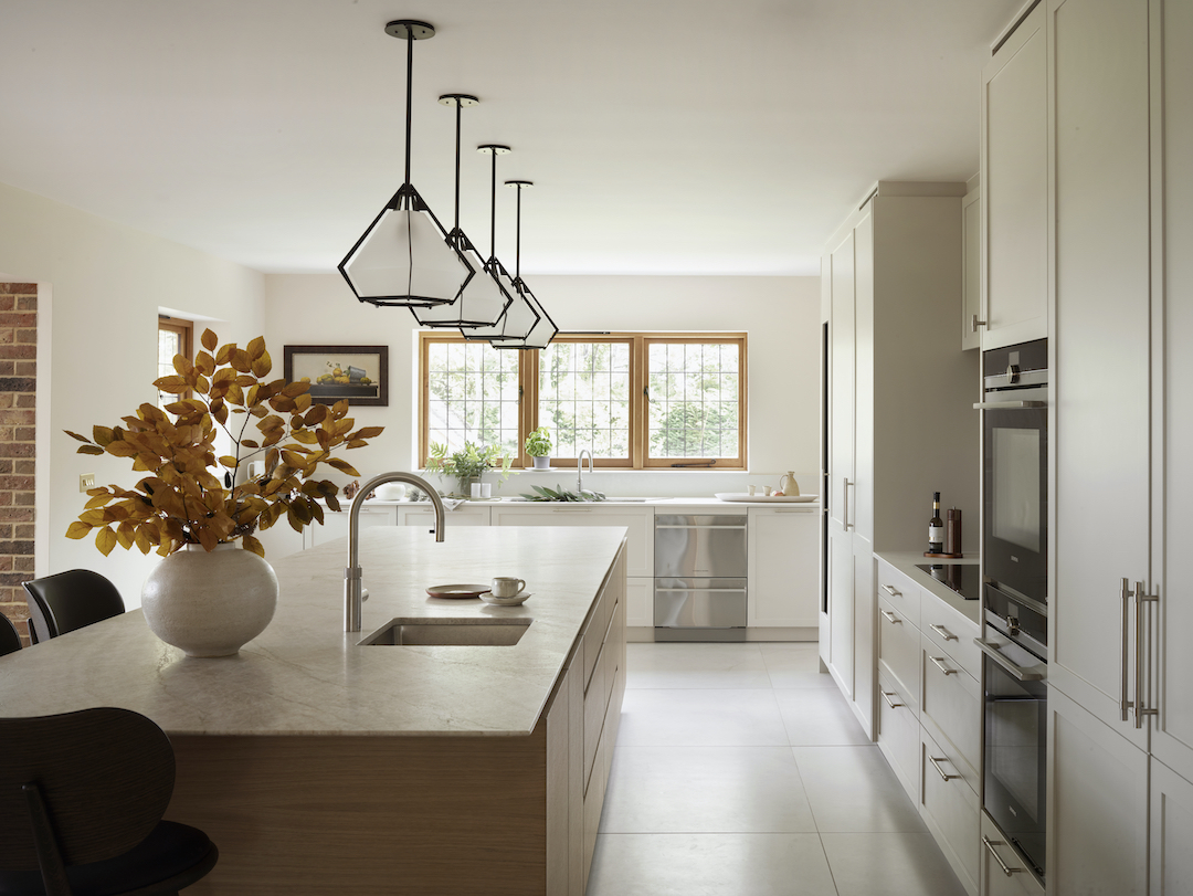 Bespoke Roundhouse kitchen with oak island, geometric pendant lights, and cream cabinetry in light-filled contemporary British home