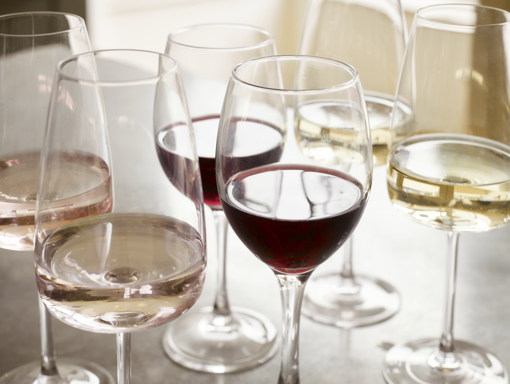Collection of wine glasses containing red and white wine varieties including rosé, displaying elegant stemware for sophisticated wine tasting and entertaining in luxury kitchen or dining setting