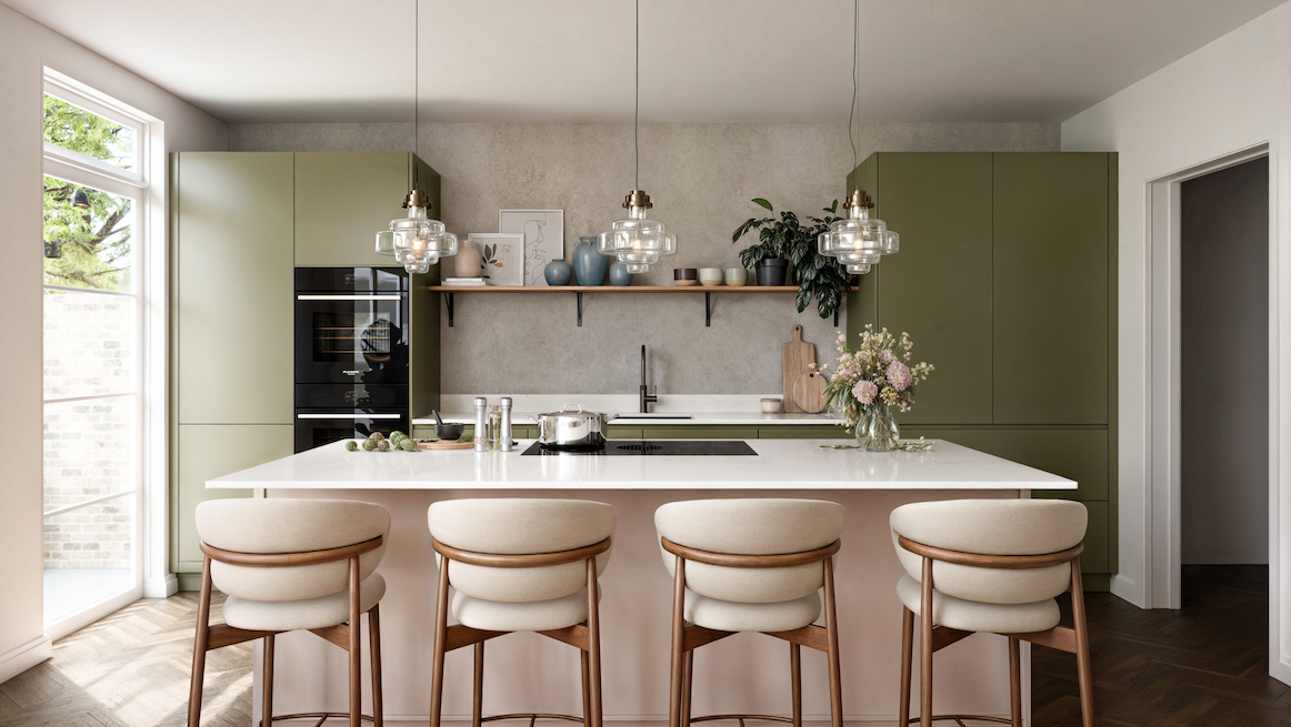 Contemporary sage green handleless kitchen with white composite island, flush-mounted induction hob, polished concrete-effect splashback, walnut floating shelf, sculptural glass pendant lights, cream upholstered bar stools with oak frames, and herringbone oak flooring