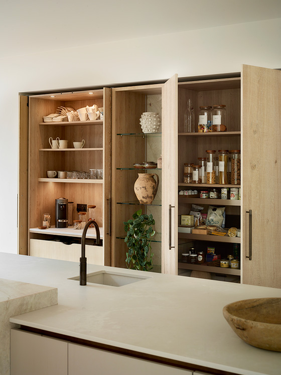 Bespoke pantry with illuminated coffee station, oak shelving, integrated storage and display cabinetry by Roundhouse Design.