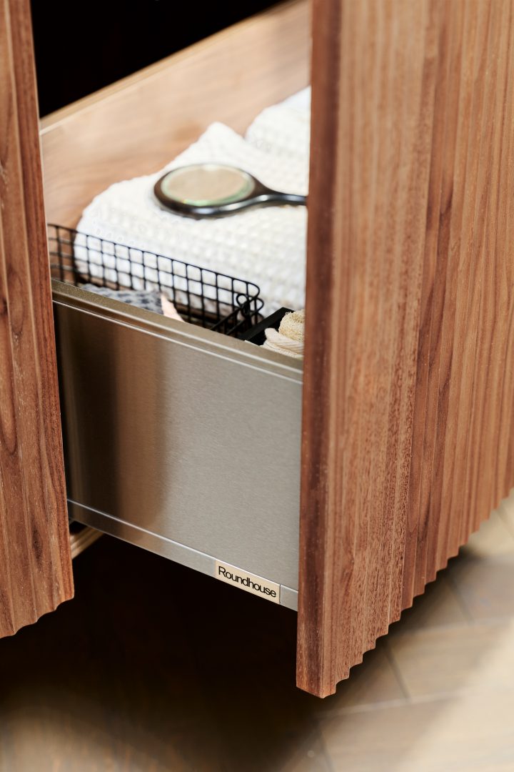 Close-up of bespoke fluted walnut bathroom cabinetry with integrated drawer storage and premium internal organisation details at the Roundhouse + Day True Wimbledon showroom.