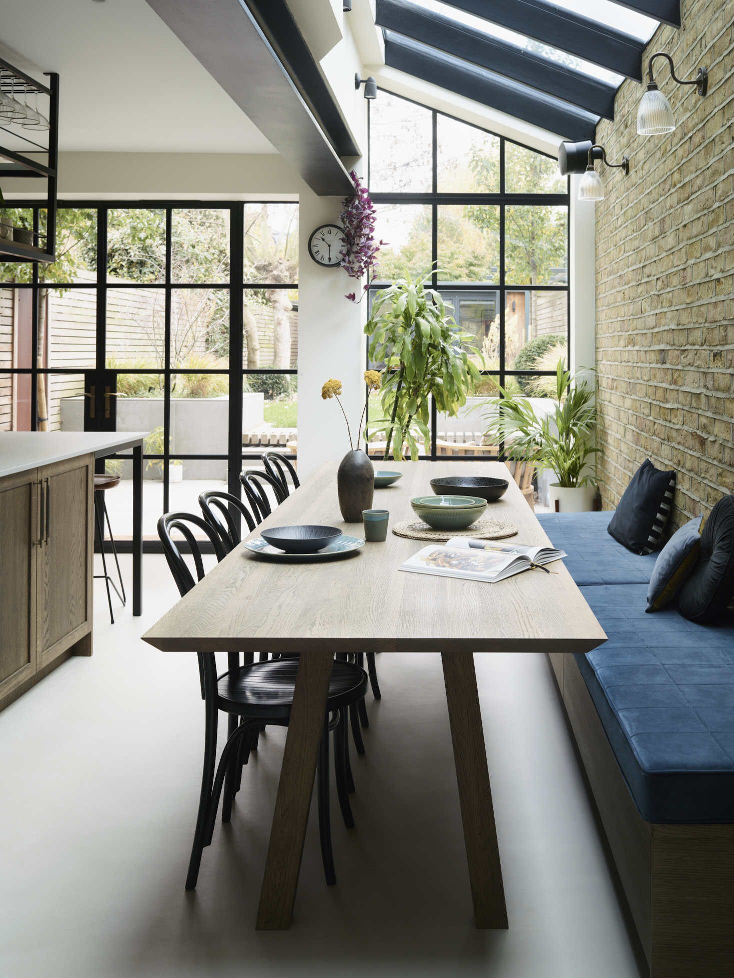 Open-plan luxury kitchen and dining space with bespoke banquette seating, designed to encourage entertaining, conversation and everyday moments at home.
