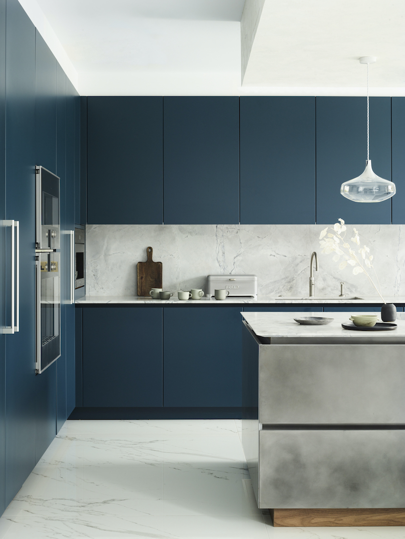 Contemporary blue kitchen with deep blue cabinetry, white marble splashback and patinated silver island.