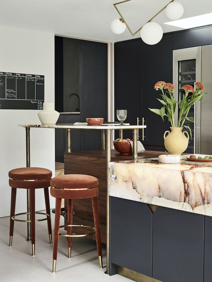 Farrow & Ball's Pitch Black bespoke kitchen with dramatic Patagonia quartzite island, walnut details and antique brass accents.