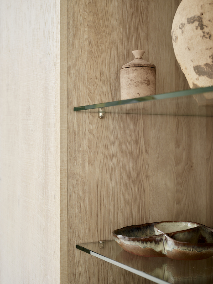 Bespoke oak cabinetry with glass shelving showcasing natural timber grain and considered material detailing