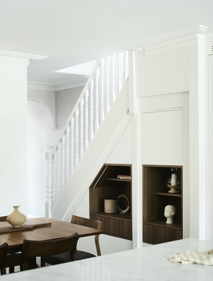 Made-to-measure under-stair storage with bespoke walnut joinery designed around an awkward architectural space