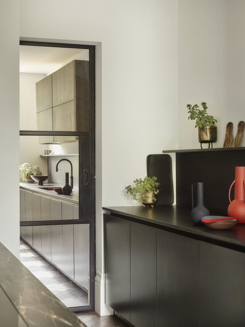 Bespoke kitchen cabinetry in a walk-in pantry just off the kitchen with dark finishes and smoked oak detailing.